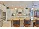 A kitchen features white cabinetry, stainless steel appliances, granite countertops and a large island with seating at 1723 Pacific Dunes Dr, Sun City Center, FL 33573