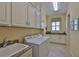 Bright laundry room featuring granite countertops, ample storage, and modern appliances at 1723 Pacific Dunes Dr, Sun City Center, FL 33573