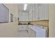 A laundry room features white cabinetry, granite countertops, and a washer and dryer at 1723 Pacific Dunes Dr, Sun City Center, FL 33573