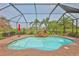 Inviting screened-in pool with waterfall feature and lush landscaping, perfect for relaxation and outdoor enjoyment at 1723 Pacific Dunes Dr, Sun City Center, FL 33573