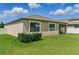 The back exterior features manicured landscaping and an enclosed lanai for relaxing at 18596 Rococo Rd, Spring Hill, FL 34610