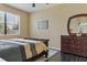 Comfortable bedroom with dark wood floors, neutral walls, and a dresser with decorative mirror at 18596 Rococo Rd, Spring Hill, FL 34610