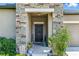 Inviting front entryway features a stone accent wall, covered porch, and a decorative front door at 18596 Rococo Rd, Spring Hill, FL 34610