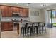 Modern kitchen with stainless steel appliances, granite countertops, an island with seating, and a tile backsplash at 18596 Rococo Rd, Spring Hill, FL 34610