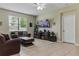 Inviting living room featuring tile flooring, comfortable seating, and a large window for natural light at 18596 Rococo Rd, Spring Hill, FL 34610