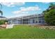 Expansive backyard featuring lush lawn and screened patio, perfect for outdoor entertaining and relaxation at 18712 Forest Glen Ct, Tampa, FL 33647