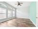 Empty bedroom with hardwood floors, white trim, natural light and a ceiling fan at 18712 Forest Glen Ct, Tampa, FL 33647