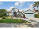 Charming home featuring well-manicured landscaping, attached two-car garage, and inviting front entrance at 18712 Forest Glen Ct, Tampa, FL 33647