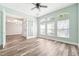 Spacious living room features hardwood floors, modern ceiling fan, and a view of the bright foyer at 18712 Forest Glen Ct, Tampa, FL 33647