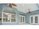 Covered patio with multiple fans, lighting and multiple doors to the backyard at 18712 Forest Glen Ct, Tampa, FL 33647