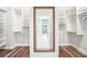 Spacious walk-in closet with wood floor and custom shelving; view to the bathroom and hall at 18712 Forest Glen Ct, Tampa, FL 33647