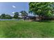Expansive backyard featuring lush green grass, mature trees, and a screened-in pool enclosure for outdoor enjoyment at 1899 Oak Park S Dr, Clearwater, FL 33764