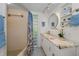 Bright bathroom with a tiled shower, vanity, and decorative round mirror with storage shelves at 1899 Oak Park S Dr, Clearwater, FL 33764