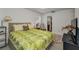 Bedroom with natural light, patterned bedding, side table, and doorway to bathroom at 1899 Oak Park S Dr, Clearwater, FL 33764