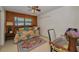 Cozy bedroom with wood paneled accent wall, ceiling fan, and stylish area rug at 1899 Oak Park S Dr, Clearwater, FL 33764
