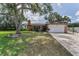 Charming single-story home with a large front yard, mature trees, and a brick facade at 1899 Oak Park S Dr, Clearwater, FL 33764