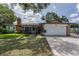 Charming brick home with a well-manicured lawn, gated entry, and an attached two-car garage at 1899 Oak Park S Dr, Clearwater, FL 33764