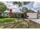 Charming brick home with a well-manicured lawn, gated entry, and attached two-car garage at 1899 Oak Park S Dr, Clearwater, FL 33764