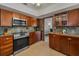 Cozy kitchen featuring wood cabinetry, stainless steel appliances, and speckled tile backsplash at 1899 Oak Park S Dr, Clearwater, FL 33764