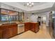 Bright kitchen with wood cabinetry, stainless steel dishwasher, and large windows overlooking a patio at 1899 Oak Park S Dr, Clearwater, FL 33764