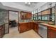A kitchen with dark wood cabinets, stainless steel appliances, and large windows overlooking the yard at 1899 Oak Park S Dr, Clearwater, FL 33764