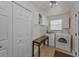 Bright laundry room with white appliances, white cabinets, and access to an exterior door at 1899 Oak Park S Dr, Clearwater, FL 33764