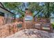 Brick outdoor kitchen featuring a built-in grill, sink, and stainless-steel doors, ideal for cooking and entertaining guests at 1899 Oak Park S Dr, Clearwater, FL 33764