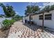 A charming brick patio with a pergola, leading to a gated entrance and highlighting the home's exterior at 1899 Oak Park S Dr, Clearwater, FL 33764