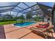 Poolside relaxation awaits with patio furniture surrounding a large, screened-in pool and spacious deck for outdoor entertaining at 1899 Oak Park S Dr, Clearwater, FL 33764