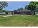 Spacious screened-in pool and patio area nestled in a large backyard with lush green grass at 1899 Oak Park S Dr, Clearwater, FL 33764
