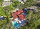 Aerial view of a home with pool, lounge chairs, and lush greenery at 208 Live Oak Ln, Largo, FL 33770