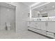 Bright bathroom features marble tiling, double sink vanity, toilet and door to adjacent closet at 208 Live Oak Ln, Largo, FL 33770