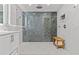Bright bathroom features a glass enclosed shower with gray tiling and marble wall plus a wooden bench at 208 Live Oak Ln, Largo, FL 33770