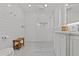 Bright all white bathroom with walk in shower, mosaic tile and wood bench at 208 Live Oak Ln, Largo, FL 33770