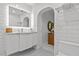 Bright bathroom with white cabinets, marble counters and tiling, view to bath at 208 Live Oak Ln, Largo, FL 33770