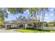 Inviting one-story home with well-manicured lawn, lush landscaping, and an attached two-car garage at 208 Live Oak Ln, Largo, FL 33770