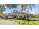 Charming one-story home boasts a manicured lawn and lush landscaping at 208 Live Oak Ln, Largo, FL 33770