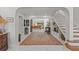 Elegant foyer with white tile floors, a staircase, and views into the living spaces at 208 Live Oak Ln, Largo, FL 33770