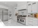 Gourmet kitchen with stainless steel appliances, white cabinets, and access to the outdoors at 208 Live Oak Ln, Largo, FL 33770
