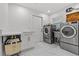 Bright laundry room with stainless steel washer and dryer and convenient folding counter at 208 Live Oak Ln, Largo, FL 33770
