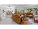 Open-concept living room featuring leather couches, marble floors, and ample natural light with easy access to the kitchen at 208 Live Oak Ln, Largo, FL 33770