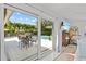 Large glass doors in the main bedroom bring the outdoors in, overlooking the pool and patio at 208 Live Oak Ln, Largo, FL 33770