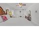 Bright main bedroom featuring a ceiling fan, white walls, and a sitting area at 208 Live Oak Ln, Largo, FL 33770