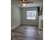 This bedroom includes a ceiling fan, gray plank flooring, and a mounted TV at 21352 Lehouier Dr, Brooksville, FL 34601