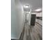 Hallway leading to the kitchen with stainless steel refrigerator and white cabinets at 21352 Lehouier Dr, Brooksville, FL 34601