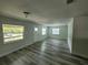 Bright living room with new gray flooring, neutral walls, and lots of natural light at 21352 Lehouier Dr, Brooksville, FL 34601