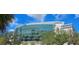 Contemporary arena featuring a modern glass facade with palm trees, blue sky, and lush green trees around it at 2328 W La Salle St, Tampa, FL 33607