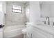 Clean bathroom showcasing white tiling, a tub, black window trim and a modern sink at 2328 W La Salle St, Tampa, FL 33607