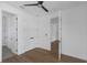 Bright bedroom with wood-look floors, ceiling fan, interior door, and a hallway at 2328 W La Salle St, Tampa, FL 33607