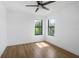 Bright bedroom with wood-look floors, ceiling fan and two windows overlooking green trees at 2328 W La Salle St, Tampa, FL 33607